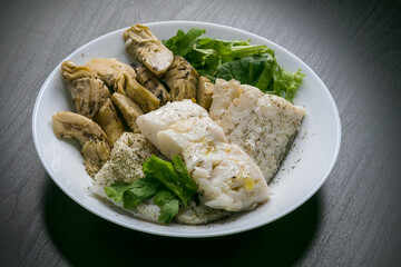 Hake fish with artichokes, parsley, fine herbs and green salad with olive oil