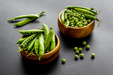 Bowl of green pea pod with beans on kitchen desk. Close up