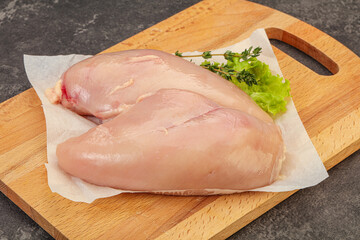 Raw chicken breast over board