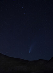 Long period comet C/2020 F3 (NEOWISE) with tail visible in night sky above the Dinara mountain in...