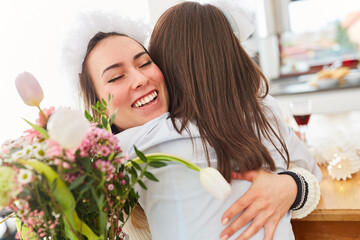 Obraz na płótnie Canvas Girlfriend congratulates bride at wedding with hug
