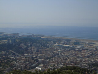 Obraz premium Genova, Italy – 07/30/2020: Beautiful scenic aerial view of the city, port, dam, sea, Cristoforo Colombo airport runway, containers shipping terminal, Pra, Voltri, and Sestri promontory from Monte Gaz
