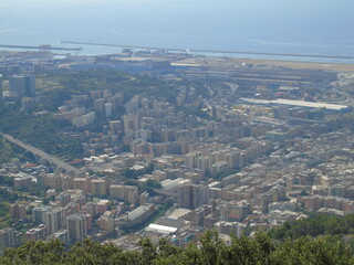Genova, Italy – 07/30/2020: Beautiful scenic aerial view of the city, port, dam, sea, Cristoforo Colombo airport runway, containers shipping terminal, Pra, Voltri, and Sestri promontory from Monte Gaz