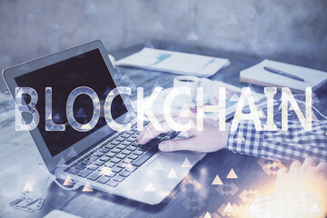 Blockchain theme hologram with man working on computer on background. Concept of crypto chain....