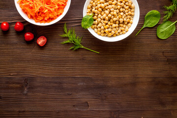 Vegetarian bowl with chickpeas and vegetables - wooden table top view copy space