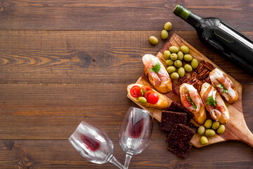 Bruschetta with prosciutto and red wine in glasses from above copy space