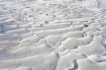 Close up view onto ribbed surface of travertine. Sharp edges formed by flowing mineral water from geothermal hot spring