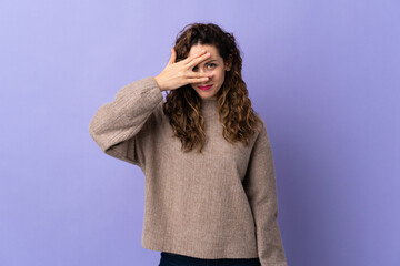Young caucasian woman isolated on purple background covering eyes by hands and smiling