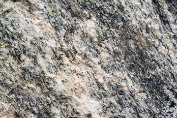 Close up view onto rough surface of split granite stone with its granular and phaneritic in texture
