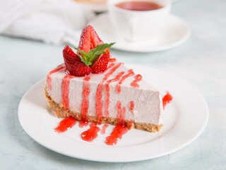 Sweet breakfast, delicious cheesecake with fresh strawberries and mint, homemade recipe without baking, on a blue stone table. Copy space.
