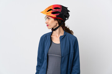 Young cyclist woman isolated on white background looking to the side