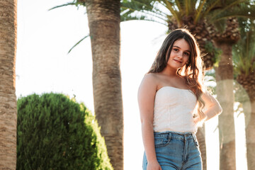 A young caucasian female in front of the trees during daytime