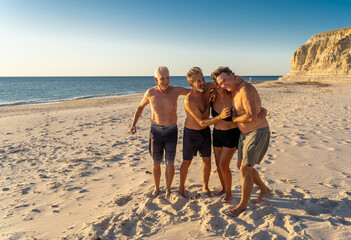 Group of mature happy active adults having fun in the beach. Long time friends