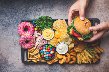 Fast food platter. Junk food concept. Unhealthy food for the heart, teeth, skin, figure, top view.