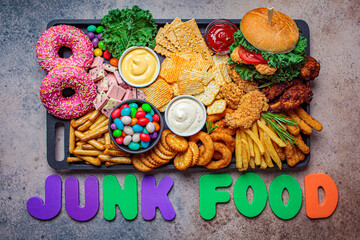 Fast food platter. Junk food concept. Unhealthy food for the heart, teeth, skin, figure, top view.