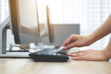 The girl's hand is cleaning the computer keyboard For cleaning bacteria and viruses Coronavirus....