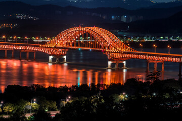 Fototapeta na wymiar Beautiful and colorful night view of grand bridge and reflection