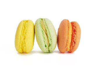 three multi-colored round baked macarons cakes isolated on a white background