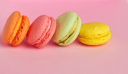 stack of baked macarons on pink background, delicious dessert made from almond flour