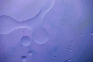 Current collection of brilliant backgrounds for your design. Close-up shot of water spills and drops on violet paint with blue stains.