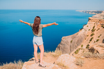 Obraz premium Tourist woman outdoor on edge of cliff seashore