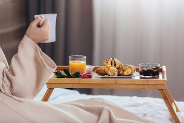 Relaxed Woman Having Breakfast in Bed, home or hotel room