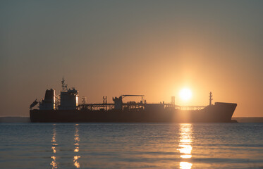 LNG tanker silhouette. Sun in background.
