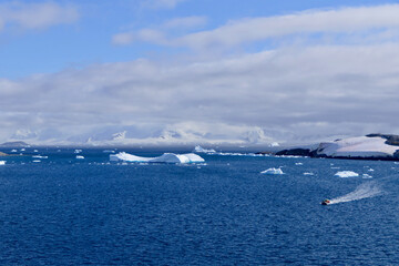 Rubber boat in antarctic landscape with blue water, iceberg, glacier, Antarctica
