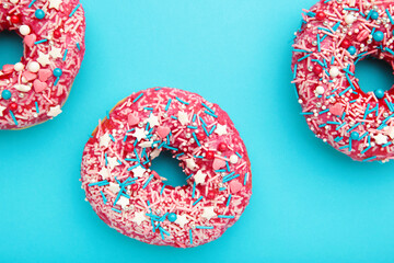 Donuts with icing on pastel blue background. Sweet donuts.