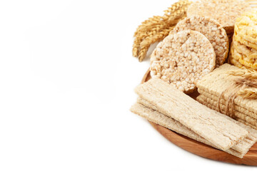 Various types of healthy whole grain crispbreads on cutting board isolated on white background.