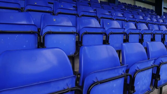 4K: Empty plastic seats in the stadium. The chairs are blue with no spectators there. Gimbal Walking Shot. Stock Video Clip Footage