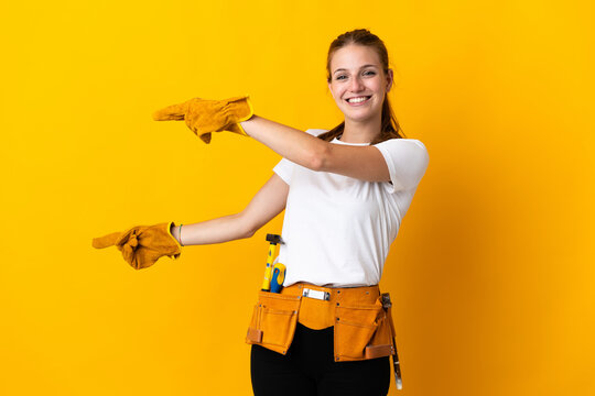 Young Electrician Woman Isolated On Yellow Background Pointing Finger To The Side And Presenting A Product