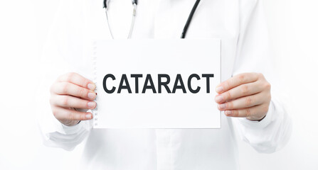 Doctor's hand shows the plate the word cataract. Medical concept.