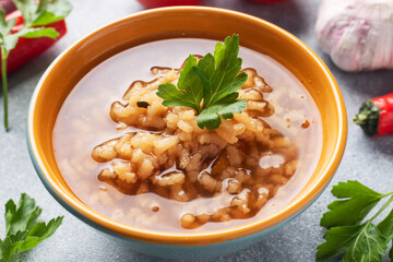 Vegetarian soup kharcho with rice and vegetables. Garlic hot pepper tomatoes.