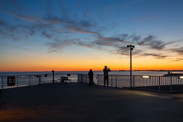 Obraz premium Zwei Fotografen fotografieren den Sonnenuntergang