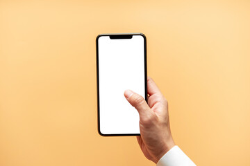 Smartphone mockup. Close up hand holding black phone white screen on yellow background. Mobile phone frameless design concept.