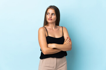 Young Uruguayan woman isolated on blue background keeping the arms crossed