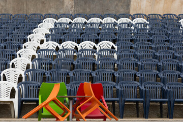 Blaue Bestuhlung bei einer Konferenz mit farbigen Stühlen auf dem Podium