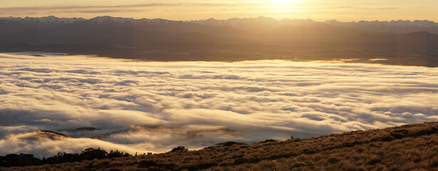 Naklejka premium Sunrise with orange cloud cover seen from Luxmore Hut in the Fiordland National Park along the Kepler Track near Te Anau in New Zealand.