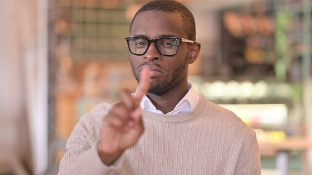 Portrait of Serious African Man saying No by Finger Sign