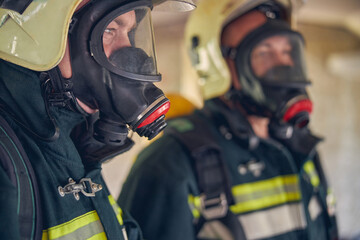 Naklejka premium Dwóch strażaków w maskach ochronnych i żółtych hełmach