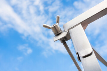 Metal silver structures shiny from industrial machines of various shapes against the background of a blue sky
