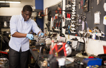 Portrait of man master who is repairing motobike in the workshop. High quality photo