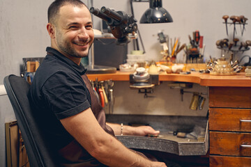 Joyous bearded craftsman smiling at the camera