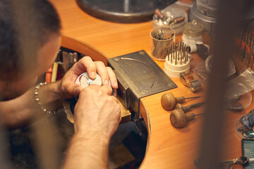 Man leaning over the engraving block ball vise