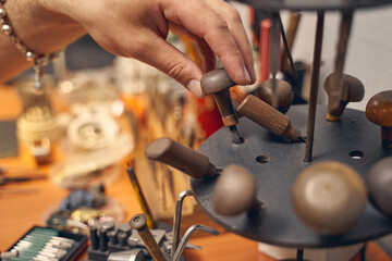 Caucasian male hand touching a jewelry instrument