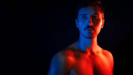 Portrait Of A Man Under Blue And Red Lights. Naked body. The concept of emancipation, tolerance