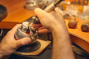 Male jeweler working with an electric soldering iron