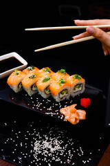 Sushi with salmon. Soy sauce, ginger, red caviar. Roles with red fish.