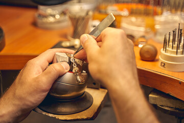 Male hands using a tool for stone setting